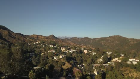 drone slow zoom in aerial view of los angeles city desert trees water city in background