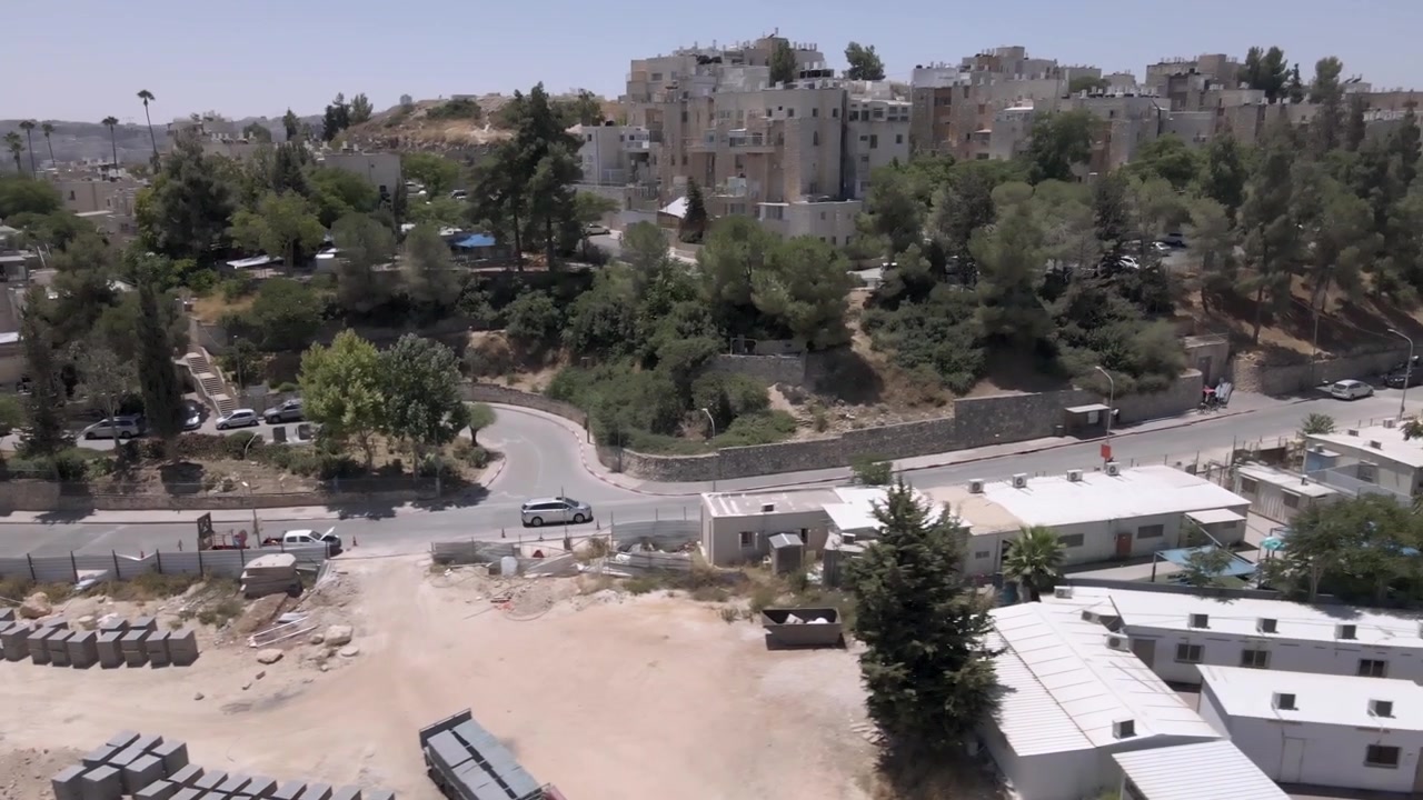 Una ripresa con drone di un'auto che guida su una strada a Gerusalemme. Una strada nel quartiere di Ramot, un quartiere nel nord della città. Toyota Sienna
