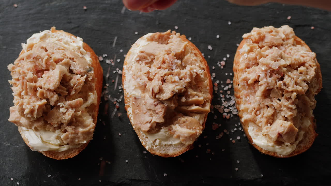 Smoked cod liver in oil in open tin can with fresh greens on wooden table. Seafoods delicacy. High quality 4k footage