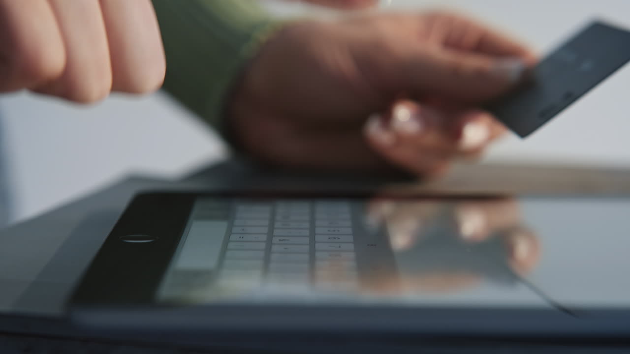 Female hands typing credit card number on tablet closeup. Woman online purchase