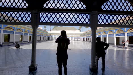 un turista tomando una foto en el palacio al badii en marrakech
