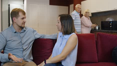 couple arguing in the living room while older couple stands in the background