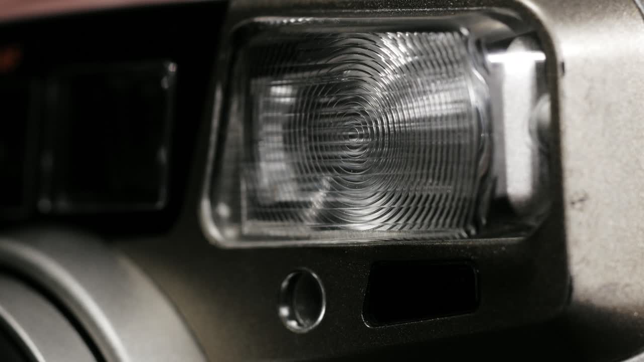 Macro of red preflash indicator blinking before flash on silver camera