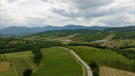 drone hyperlapse along country road, hilly region with farms