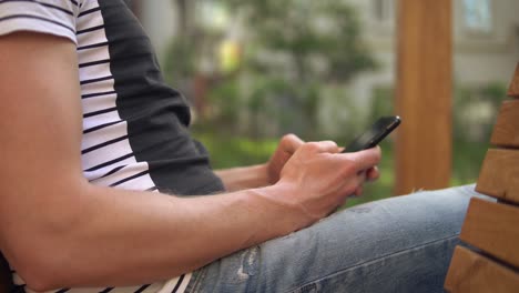 cerca de las manos de un hombre sosteniendo un teléfono móvil