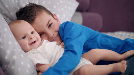 retrato de un niño abrazando a un bebé. hermanos felices con el bebé. hermanos felices