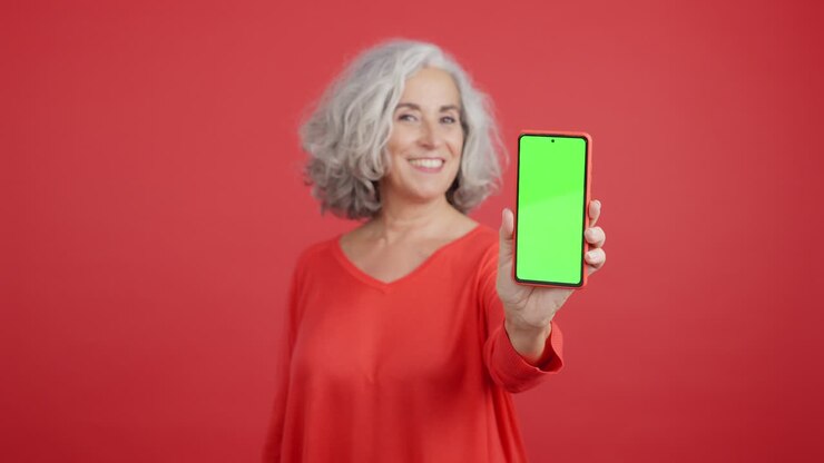 mujer sosteniendo un teléfono inteligente con pantalla verde
