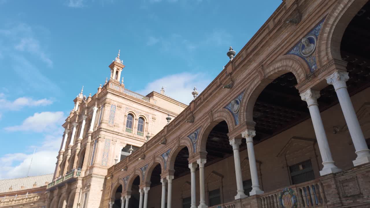 Architectural detail of Plaza de Espana in Seville, Andalusia, Spain, showing arches, columns and azulejo tiles with a blue sky