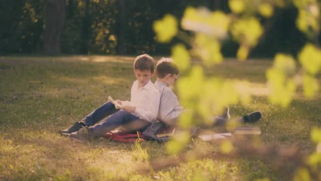 Los-Niños-Se-Sientan-Espalda-Con-Espalda-Preparándose-Para-Los-Exámenes-Escolares-En-El-Parque.