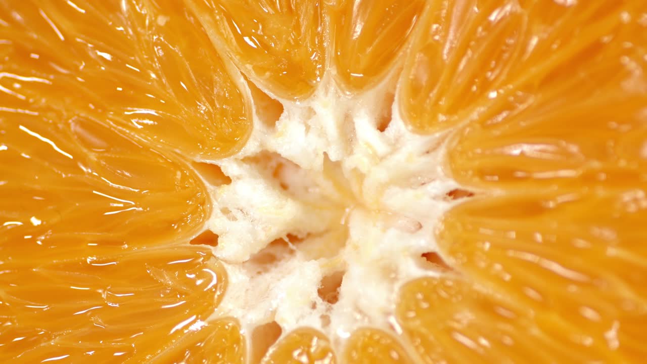 la rebanada de naranja gira lentamente. fondo macro.