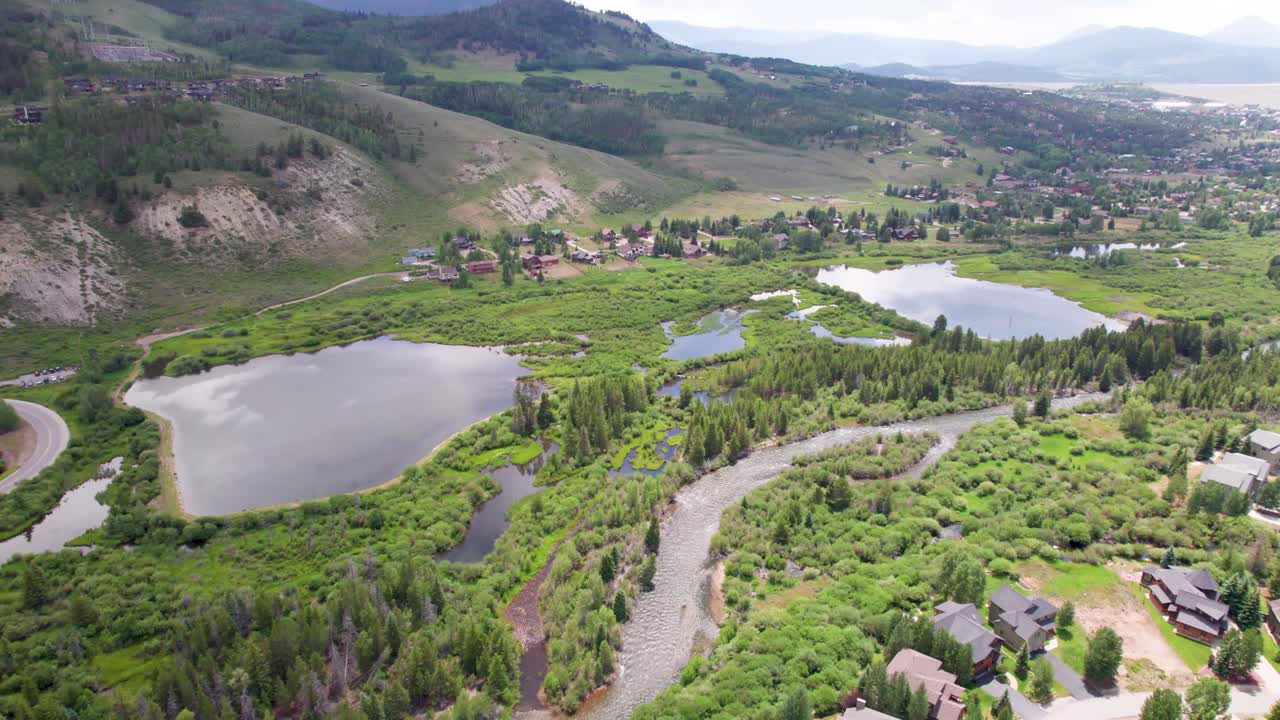 Aerial flight over a neighborhood and pond in Silverthorne, Colorado. Several ponds and the Blue River can be seen.