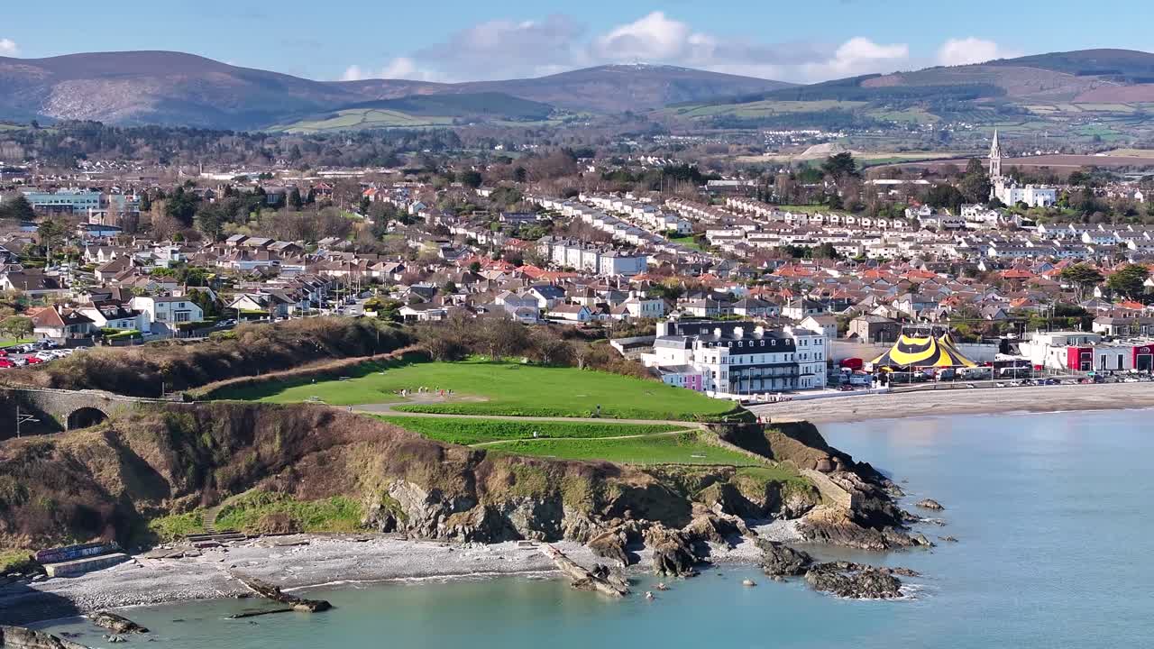 Persone che praticano yoga in cerchio e la costa rocciosa di Bray Head, Bray Town. Paesaggio irlandese ripreso da drone