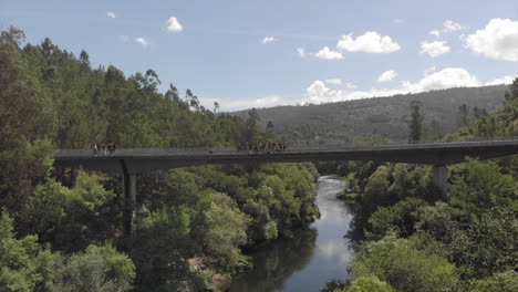 people on the bridge with an adventurous man bungee jumping in spain - wide shot