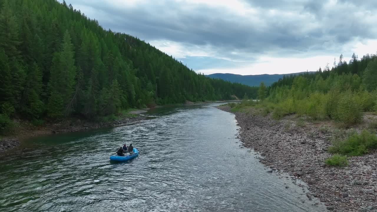 Turisti che fanno rafting sul fiume Flathead attraverso una foresta di pini in Montana, USA
