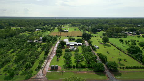 Aerial-Drone-of-Large-Tropical-Rural-Block-Pull-Back-Away-From-Home-Frontage-along-Dirt-Road-Over-Forest