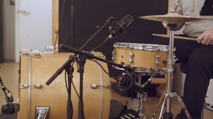 Slow motion (60 fps) di un batterista che suona un groove in uno studio di registrazione con microfoni