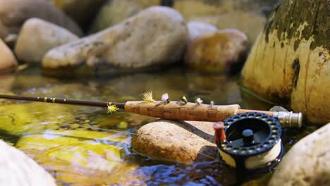 Fly-fishing-rod,-reel-and-hook-on-rock