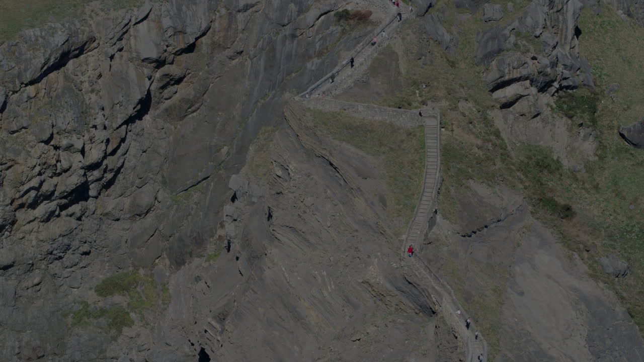 туристы поднимаются по каменным ступеням островка гастелугатксе на севере испании