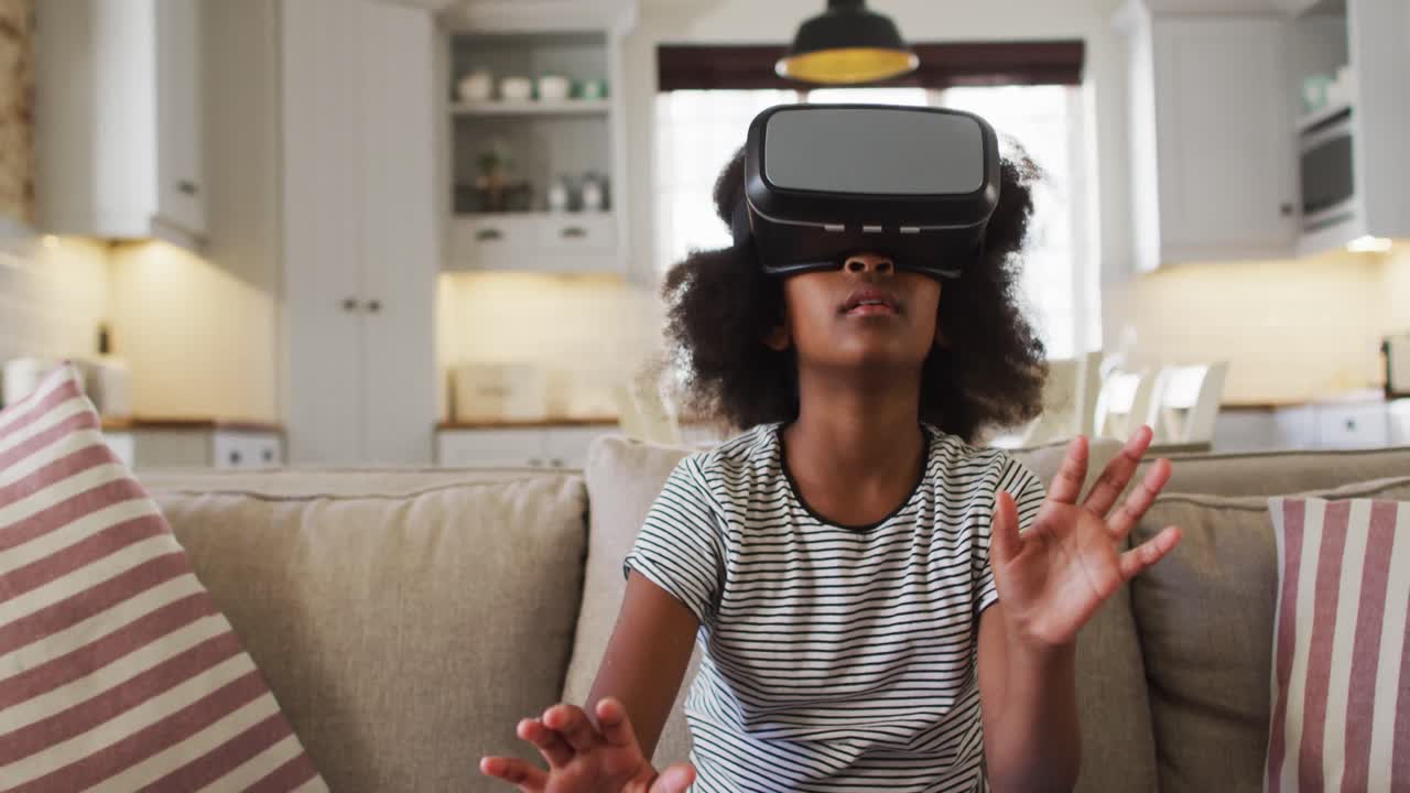 African american girl sitting on couch wearing vr headset