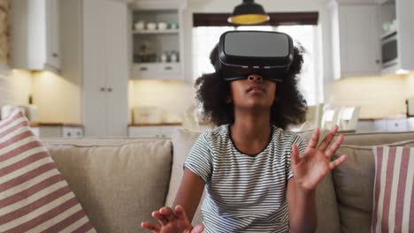 african american girl sitting on couch wearing vr headset