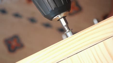 using a drill to screw in wood