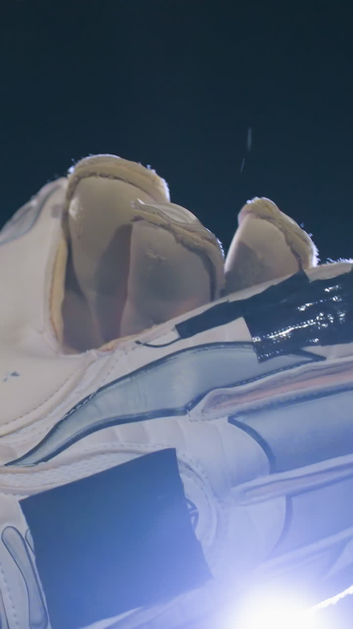 primer plano de la mano con guantes aplaudiendo junto con costuras intrincadas y relleno reforzado capturado durante la actividad al aire libre bajo luz suave