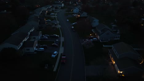 american housing area with parking cars in suburb district and warm lights in windows