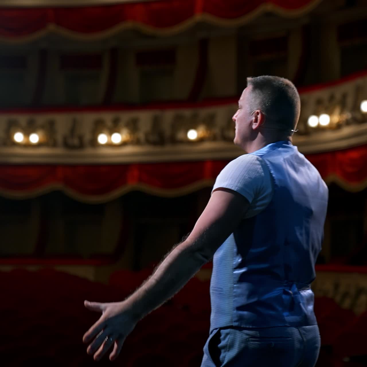 Middle age male entertainer, presenter or actor on stage. Public speaker gives performance. Man in theater