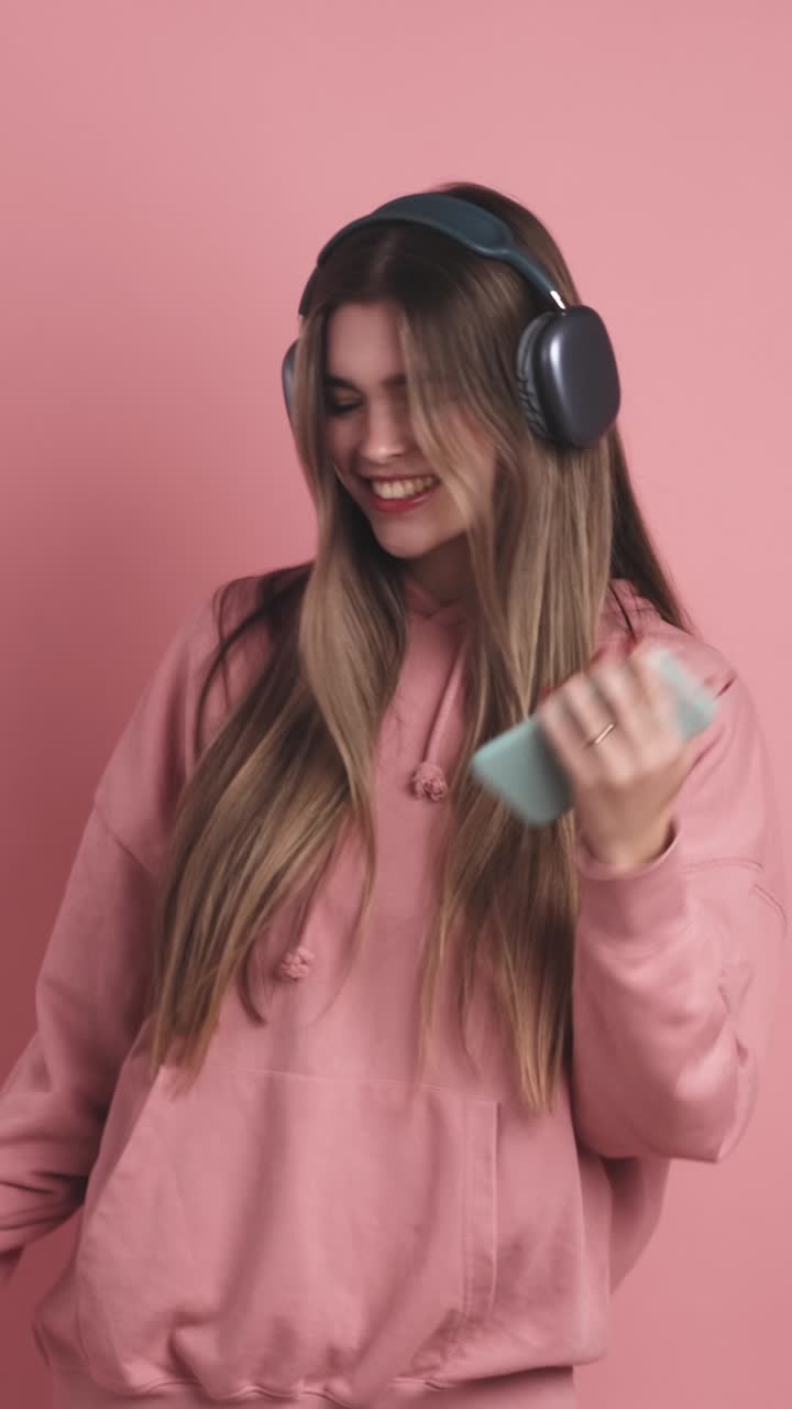 Cheerful young woman with headphones and smartphone