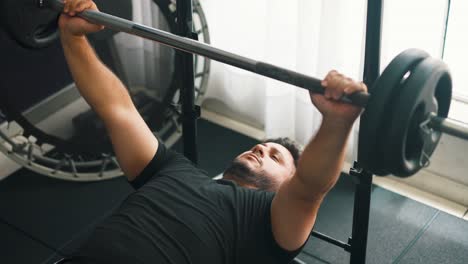 Caucasian-young-man-doing-bench-press-workout-with-a-barbell-at-the-gym