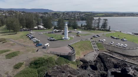 aerial orbit around lighthouse above steps leading down to blowhole and open salt water pool in kiama nsw australia