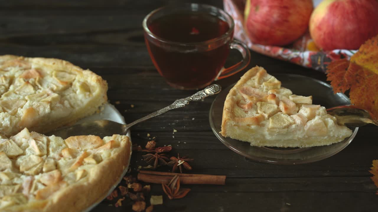 pieza de pastel de manzana casera charlotte de manzanas rojas y amarillas. naturaleza muerta sobre el tema del otoño, cosecha de manzanas y pasteles caseros en una mesa de madera oscura.