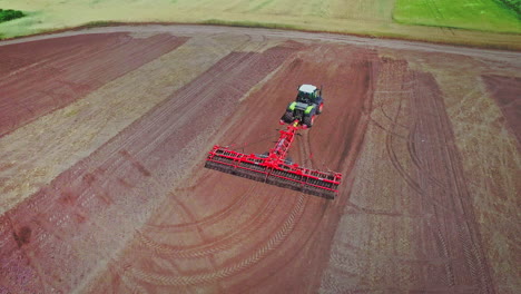 Farming-tractor-with-trailer-plowing-on-ploughing-field.-Rural-farming