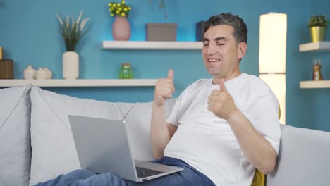 hombre siguiendo el trabajo en la computadora portátil con una expresión relajada y feliz.