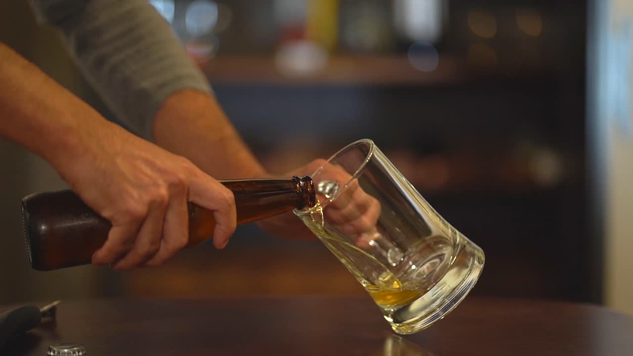 Primo piano dell'apertura di una bottiglia di birra. Apertura e servizio della birra