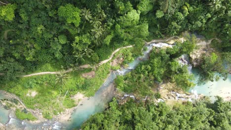 La-Gente-En-Las-Cataratas-Kawasan-En-Badian,-Cebú,-Con-El-Río-Matutinao-Que-Fluye-A-Lo-Largo-De-Un-Exuberante-Sendero-De-Selva