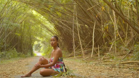 model sits at the trail of an epic scenic bamboo cathedral on the caribbean island of trinidad