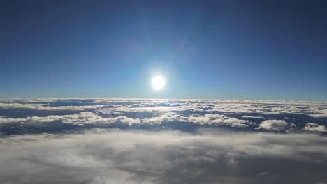 sun disc going down during sunset. aerial footage taken from a a jet cockpit while flying over a layer of stratus clouds at sunset. hyper lapse. 4k