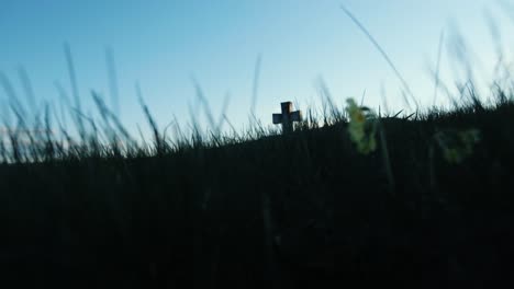 old cross buried in grass