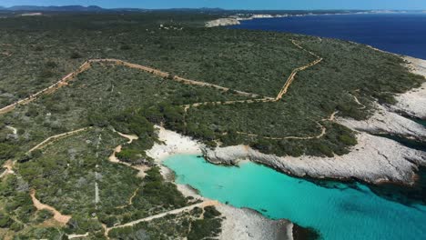 es talaier virgin white sand beach in menorca spain seen from above with rugged track leading to the location