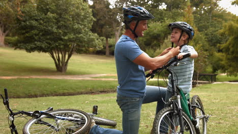 Vater-Befestigt-Seinem-Sohn-Im-Park-Einen-Fahrradhelm