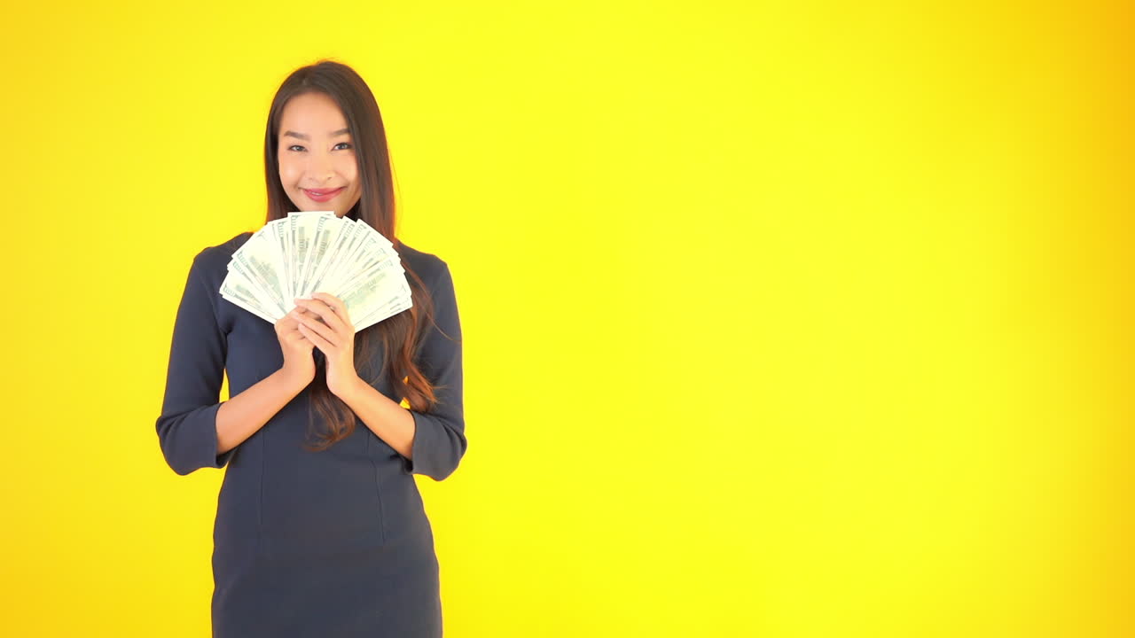 Pretty wearing the office dress outfit lady woman holding a big pile of money in her hands isolated yellow background
