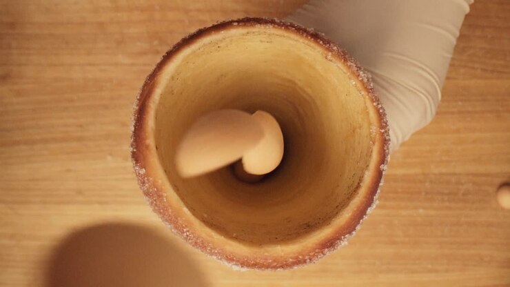 Biscuits being dropped inside the cone of spit cake, top-down cinematic slowmo