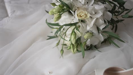 elegant bridal bouquet on white wedding dress backdrop