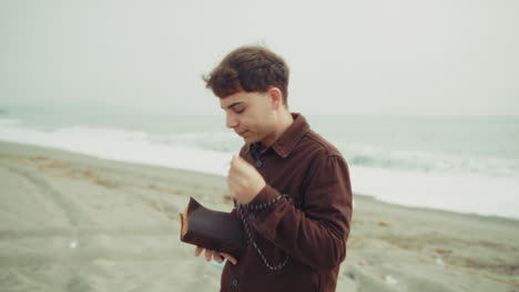 christian devoted man starting a prayer on his knees at the beach