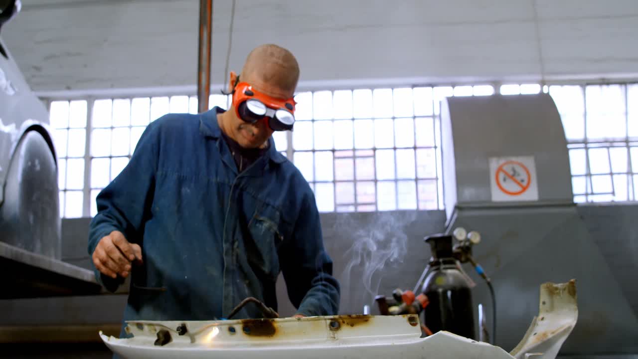 mecánico usando una antorcha en un coche parte 4k