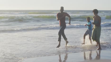 video de una feliz familia afroamericana divirtiéndose en la playa