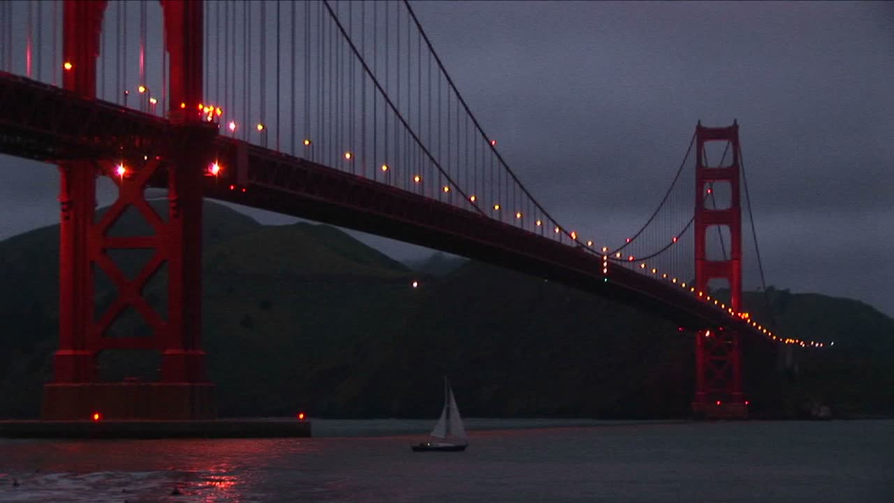 una vista de gusano del puente golden gate por la noche con sus luces reflejadas en el agua