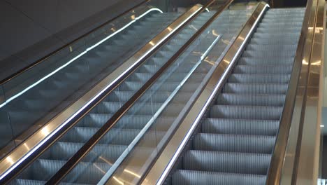 a silver escalator going upwards in a modern building