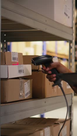 vertical video black female worker using scanner checking airway bill numbers in inventory